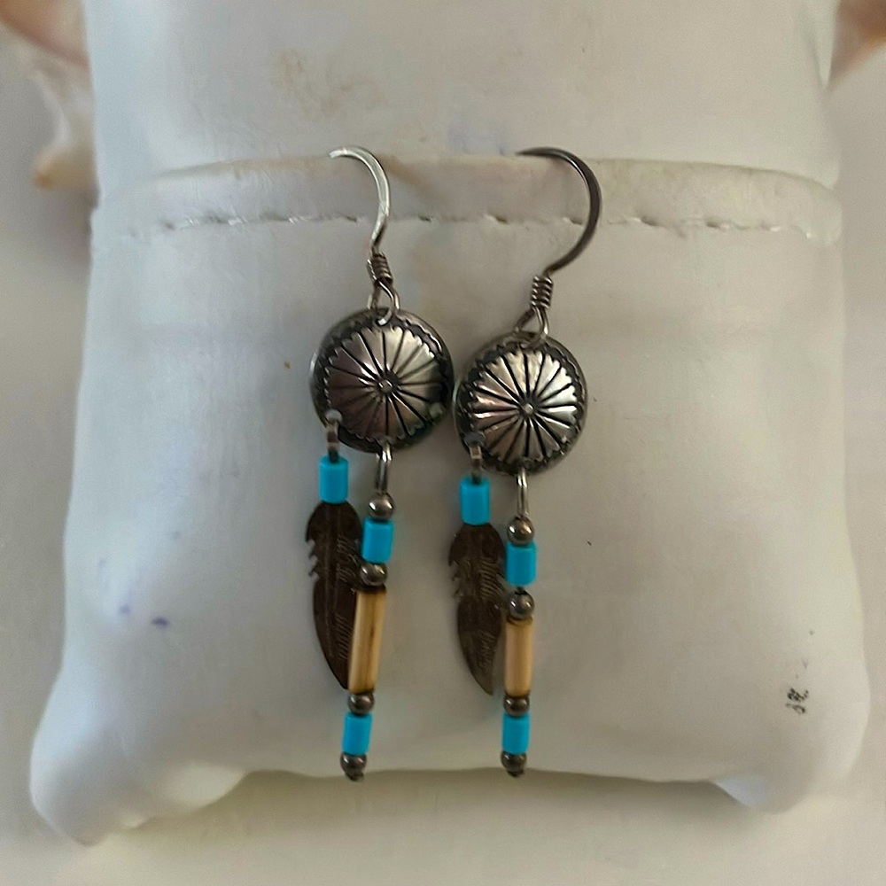 Cute little silver tone shield and feather dangle earrings